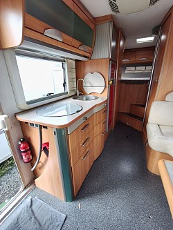 Kitchen with wardrobe and rear fixed bed beyond.
